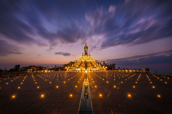 Hàng trăm ngọn đèn lấp lánh dưới chân tượng Phật trên đỉnh núi. 